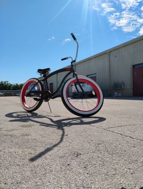 Custom black cruiser with red-wall tires shot in the Florida sun