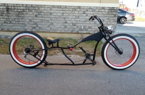 Full stretch lowrider build with red-wall tires and a raked front end