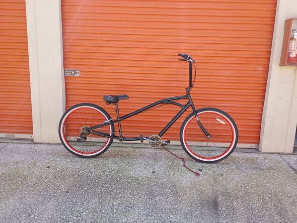 Custom tandem cruiser against the orange shop door